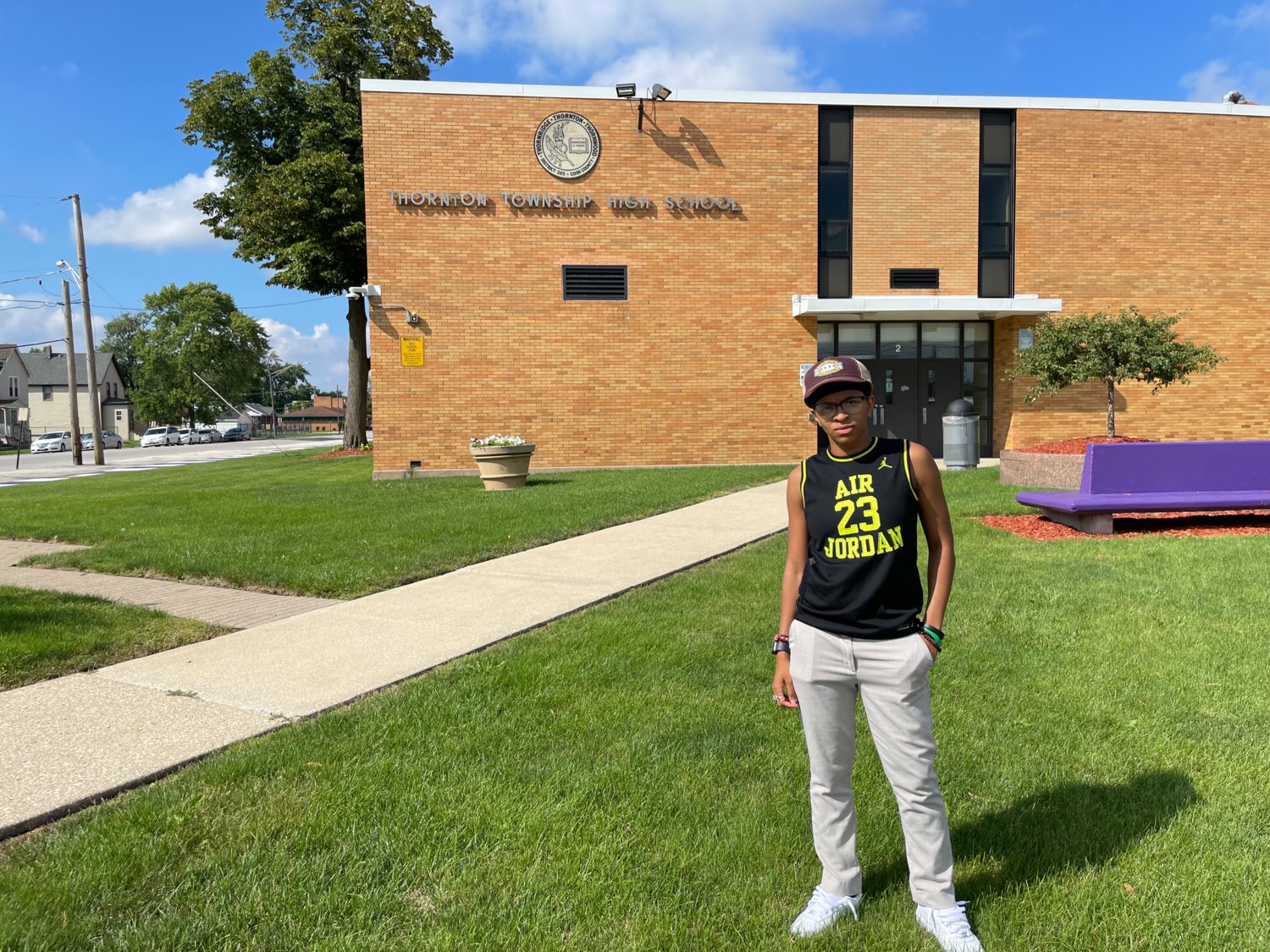 Amethyst Davis, founder of the Harvey World Herald, stands in front of Thornton Township High School, which got the nickname “Harvey World.”